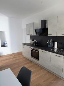 a kitchen with white cabinets and a black counter top at Ferienwohnung Löwenrevier in Winningen