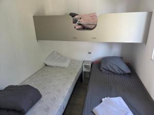 two beds in a small room with a mirror at FMLODGE la cabane du soleil au sable du midi in Sérignan +7 photos