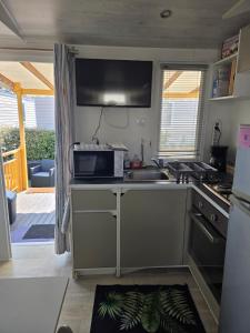 a kitchen with a sink and a microwave at FMLODGE la cabane du soleil au sable du midi in Sérignan
