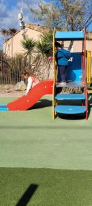 a child on a slide at a playground at FMLODGE la cabane du soleil au sable du midi in Sérignan