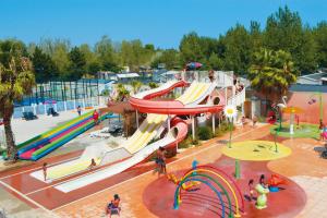 a water park with a slide at a playground at FMLODGE la cabane du soleil au sable du midi in Sérignan