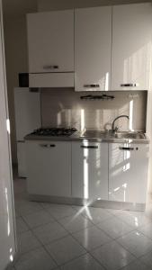 a white kitchen with white cabinets and a sink at B&B Oro Puro in Fondi