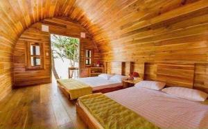 a bedroom with two beds in a wooden room at Coto Queen in Nam Cap