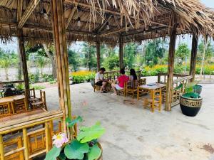 a group of people sitting in a pavilion at a restaurant at Coto Queen in Nam Cap