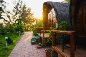 a house with a brick walkway next to a building at Coto Queen in Nam Cap +1 photo