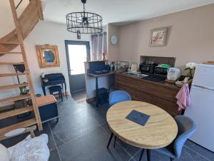 a kitchen and dining room with a table and a refrigerator at Le Pigeonnier in Rosult