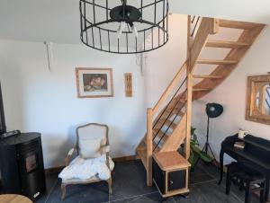 a room with a staircase and a chair and a piano at Le Pigeonnier in Rosult