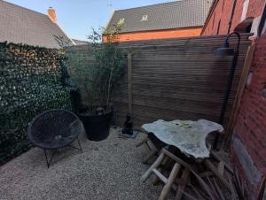 a patio with a table and a bench and a fence at Le Pigeonnier in Rosult
