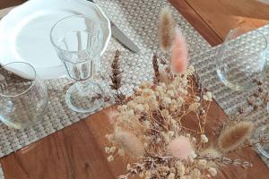 a table with glasses and dried flowers on it at Gîte de charme Beaujoyeulx in Molineuf