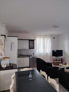a living room with a black table and a kitchen at Rifugio Sereno de Tajo in Taglio di Po