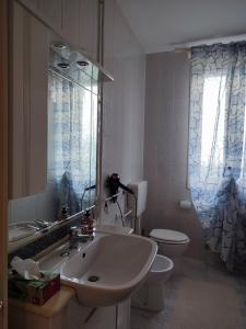 a bathroom with a sink and a toilet and a mirror at Rifugio Sereno de Tajo in Taglio di Po +3 photos
