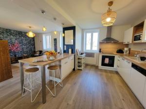 a kitchen with a table and chairs in a room at Maison Céline - Jardin clos et Parking Privé Gratuit in Crevant-Laveine