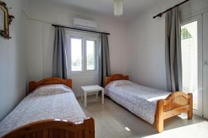 a bedroom with two beds and a window at Amethyst - holiday apartment in Likotinaréa +30 photos