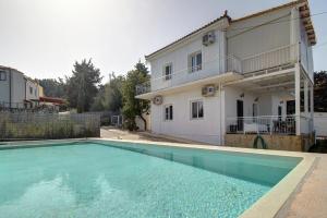 a house with a swimming pool in front of a house at Amethyst - holiday apartment in Likotinaréa
