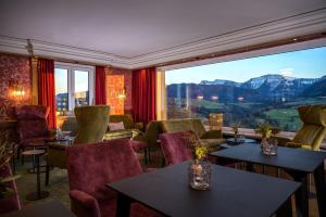 a room with tables and chairs and a large window at Allgäuer Panoramahotel in Oberstaufen