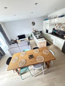 a kitchen and living room with a wooden table and chairs at Charmant appartement à Roanne in Roanne