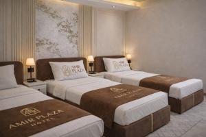 a hotel room with three beds in a room at AMIR PLAZA hotel in Akmechetʼ