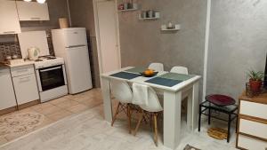 a kitchen with a white table with chairs and an orange on it at Jela - Spacious Two-Bedroom Apartment near City Center with Free Parking & Wi-Fi in Podgorica +7 photos