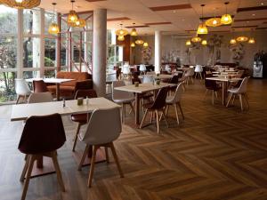 a restaurant with tables and chairs and windows at ibis Styles Chinon in Chinon