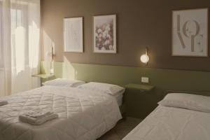 a bedroom with two beds and a window at Hera Home B&B in Serra Pedace