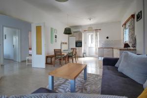 a living room with a couch and a table at Amethyst - holiday apartment in Likotinaréa