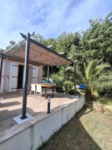 a pavilion with a table and chairs on a deck at La Motte in La Motte