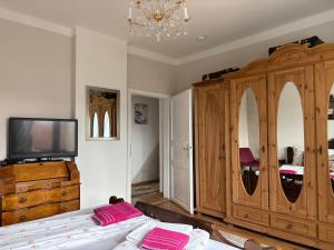 a bedroom with a large wooden cabinet and a tv at Apartments Let Me In in Pörtschach am Wörthersee