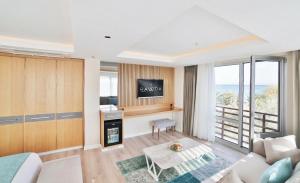 ein Wohnzimmer mit Sofa und Fernseher in der Unterkunft Rawda Resort Hotel Altinoluk in Altınoluk