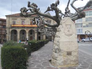 a statue next to a tree on a sidewalk at ALOJAMIENTO MONTE EDILLA Naturaleza, Confort y Recarga Eléctrica in Quintana de los Prados