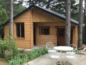 a small cabin with a table and chairs in front of it at Le Mas de la Pinède in Bollène