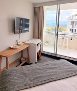 a hotel room with a bed and a desk and a window at Marcoola Surf Air Hotel Room 2515 in Marcoola