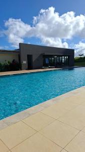 a large swimming pool with a building in the background at Verdant Comfort Apartment in Moka