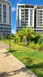 a park with palm trees in front of a building at Verdant Comfort Apartment in Moka