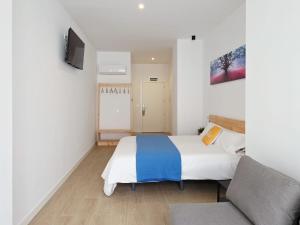 a small bedroom with a bed and a couch at Bilbao ROOMS & KITCHEN Zabalburu in Bilbao