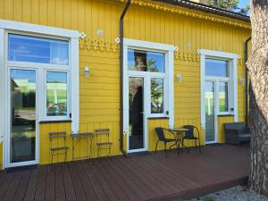 a yellow house with chairs and a table on a deck at A&A Apartment Vilnius 2 in Vilnius