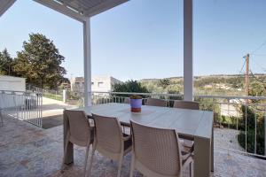 a dining room with a table and chairs on a balcony at Amethyst - holiday apartment in Likotinaréa