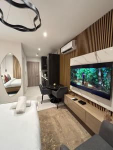 a bedroom with a large flat screen tv and a bed at LoxwoodStudio by UniqueView in Accra