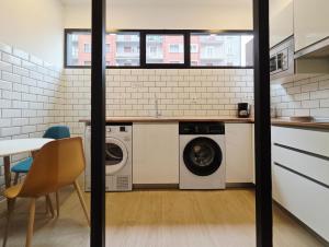 a kitchen with a washer and dryer in a room at Bilbao ROOMS & KITCHEN Zabalburu in Bilbao