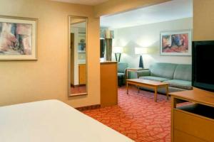 a hotel room with a bed and a living room at The Lodge at Roseburg in Roseburg