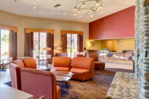a living room with orange furniture and a kitchen at The Lodge at Roseburg in Roseburg