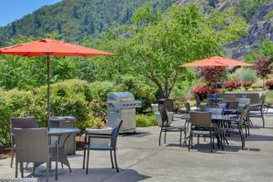 a bunch of tables and chairs with umbrellas at The Lodge at Roseburg in Roseburg