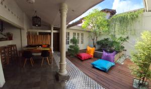 a patio with colorful pillows on a wooden deck at The Patio Yogya in Yogyakarta