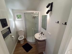 a bathroom with a shower and a toilet and a sink at BEJOT domki nad jeziorem in Wysoki Most +18 photos