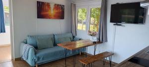 a living room with a blue couch and a table at BEJOT domki nad jeziorem in Wysoki Most