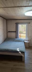 a bedroom with a bed in a room with a window at BEJOT domki nad jeziorem in Wysoki Most