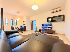 a living room with a couch and a flat screen tv at Ultimate Group Getaway Near St Julian's & Seafront in San Ġwann