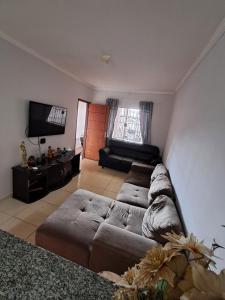 a living room with a couch and a flat screen tv at Recanto Campo Belo in Monte Sião