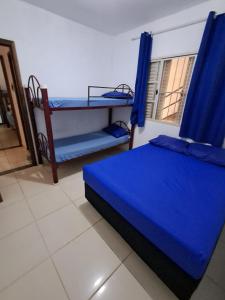 a bedroom with two bunk beds with blue curtains at Recanto Campo Belo in Monte Sião +14 photos