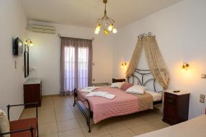 a bedroom with a bed with a pink blanket at Villa Andromeda in Amorgos