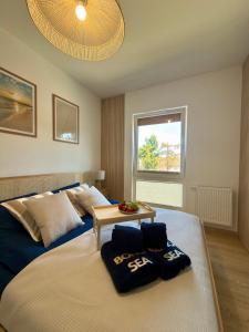 a bedroom with a large bed with a table on it at Apartament Boho Let's Sea Gąski in Gąski +33 photos